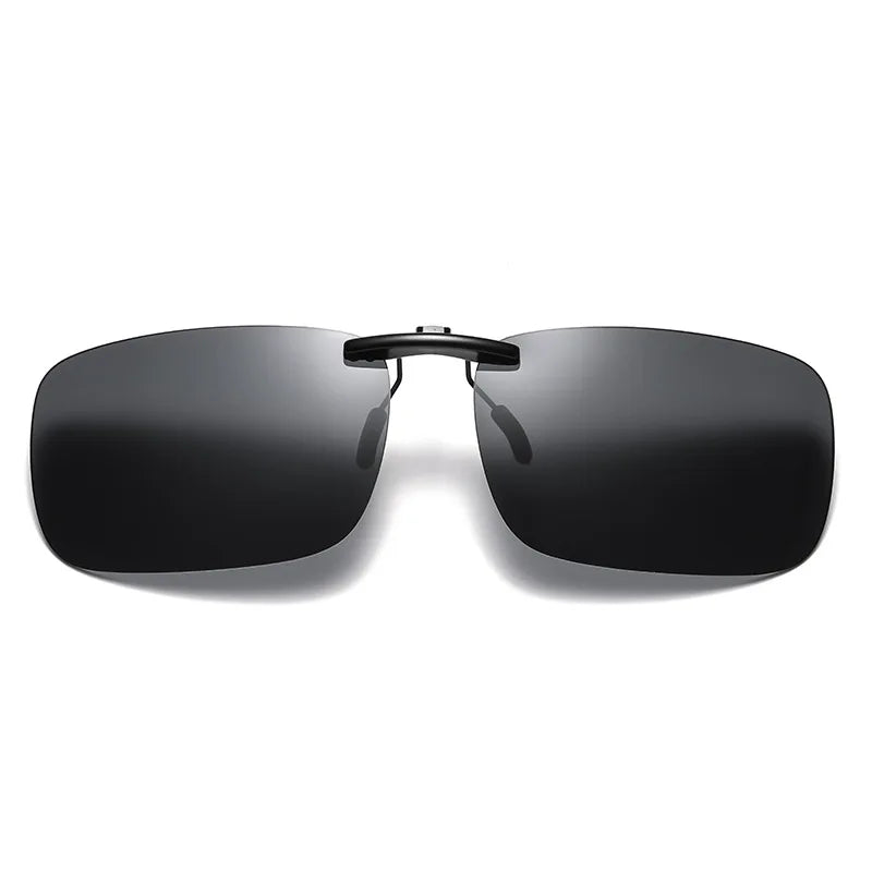 On a white background is a pair of Honey Joe Polarized Clip-On Sunglasses, showcasing sleek, rimless design with dark rectangular lenses and a thin black bridge. The minimalist style enhances modernity and provides UV400 protection.