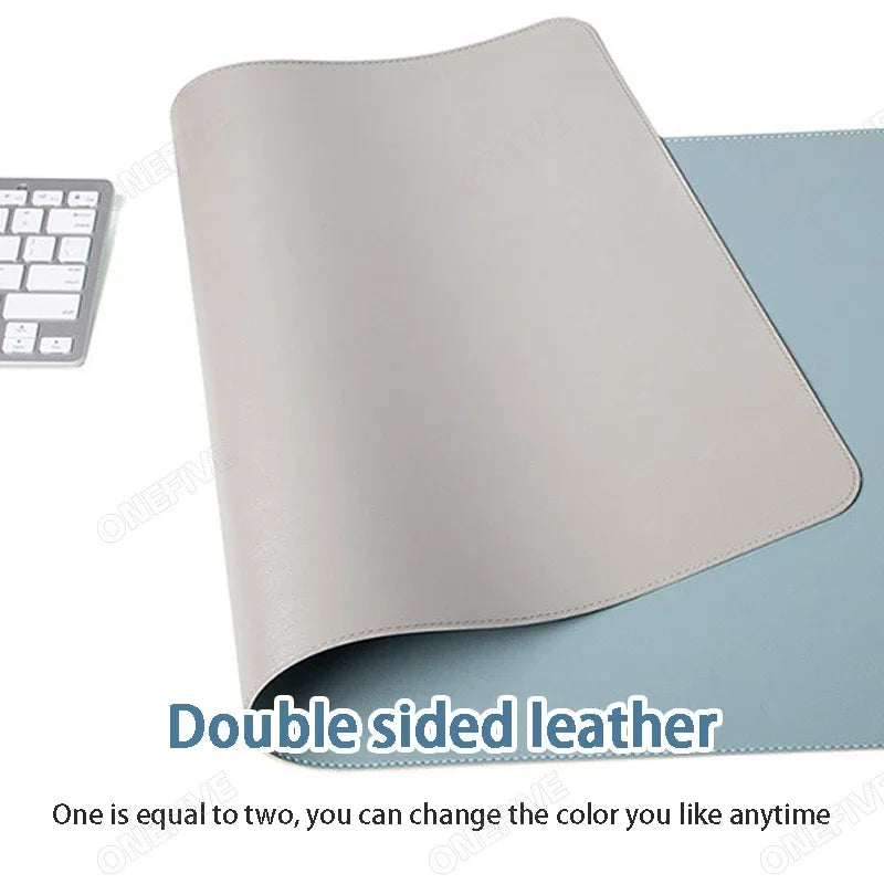 A keyboard sits next to the AIPHY Large PU Leather Mouse Pad—a stylish, double-sided mat with grey on one side and blue on the other. The partially flipped design showcases both colors, highlighting its versatility. Text reads: One is equal to two; change the color you like anytime.