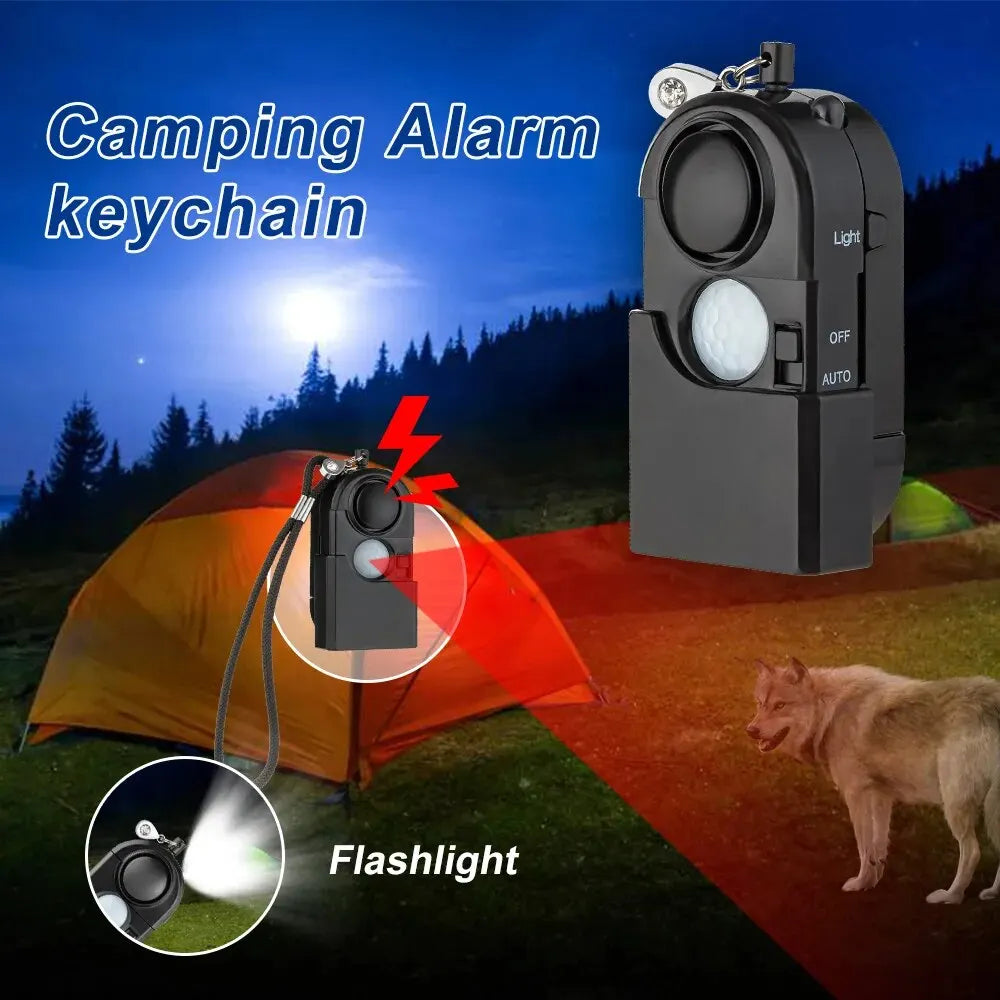 The KERUI Mini Motion Detector Alarm - 120DB Siren is shown in front of a tent at night, with a dog nearby. This personal security device doubles as a flashlight and features an alert symbol highlighting its loud alarm.