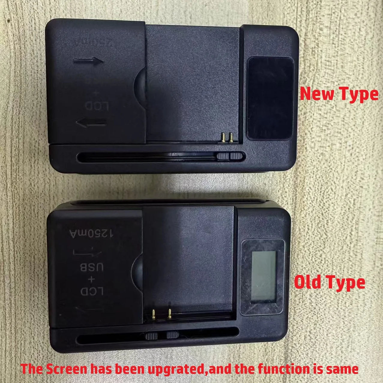 Two rectangular black electronic devices are on a wooden surface. The top, labeled YIBOYUAN Universal USB Battery Charger with LCD Indicator, features a blank screen and versatile compatibility. The bottom one has a small screen. Text reads, The screen has been upgraded; the function remains the same.
