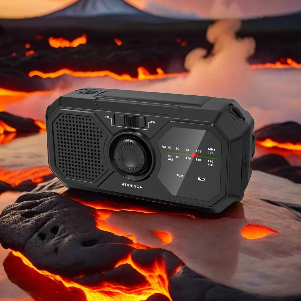 The Sayin Portable Solar Radio with Power Bank & Flashlight sits on a surface resembling hot lava. Amidst a dramatic volcanic backdrop with smoke and towering peaks, it stands ready as an essential emergency preparedness tool.