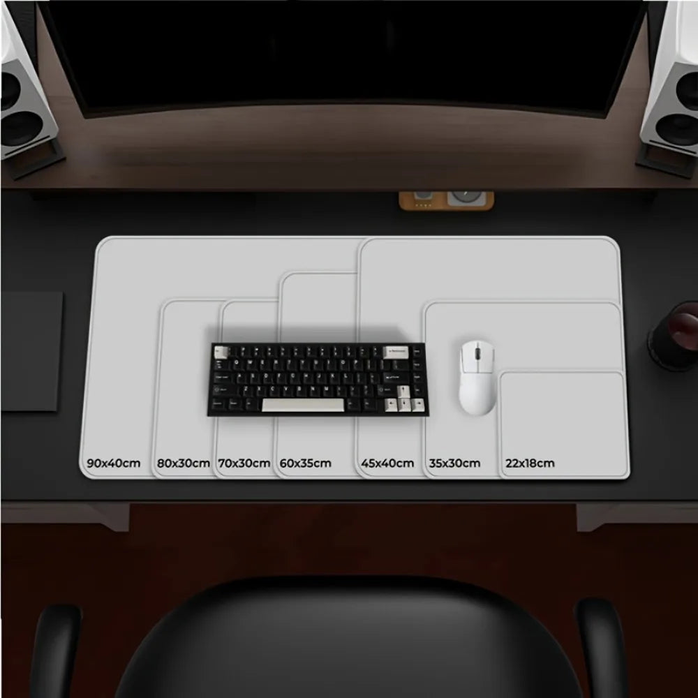 A desk showcases a keyboard, mouse, and various white desk pads from 22x18cm to 90x40cm, each marked by size. The Large Terrain Map Gaming Mouse Pad - Non-Slip & Durable is included among them. Two speakers and a monitor complete the scene.