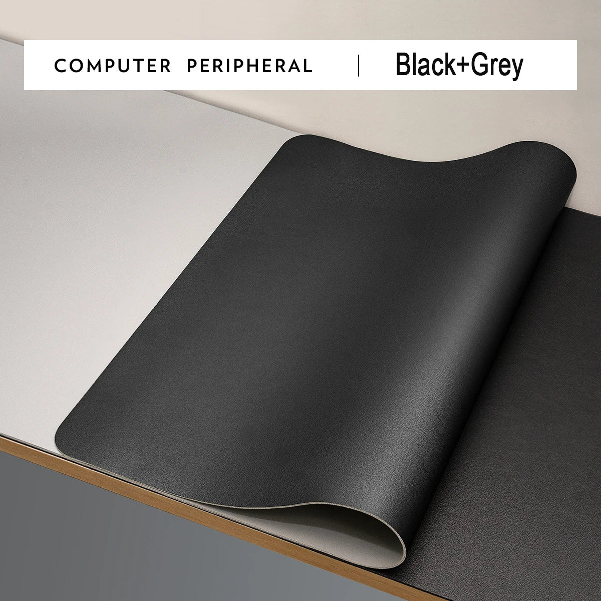 A large black and grey desk mat with a non-slip base is partially unrolled on a desk. The top left corner displays the text COMPUTER PERIPHERAL | Xummen Large Mouse Pad - Waterproof PU Gaming Desk Mat for ultimate durability and style.