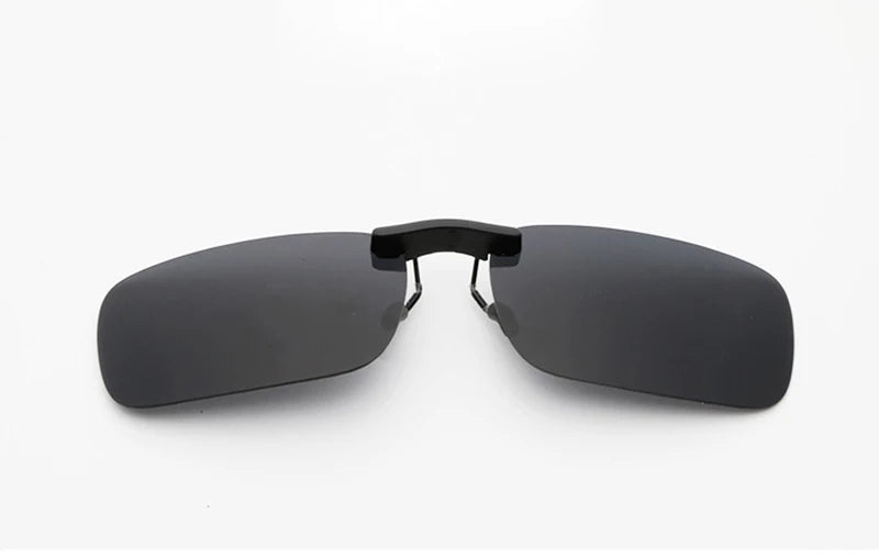 The Honey Joe Polarized Clip-On Sunglasses boast sleek, dark-tinted rectangular lenses with a black nose bridge, providing UV400 protection against a plain white background.