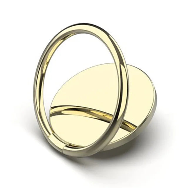 The Luxury Metal 360° Rotation Mobile Phone Ring Holder, gold-colored and circular, features a smooth round base with a hinged ring. It stands upright on a white background, accentuating its sleek and minimalistic design.