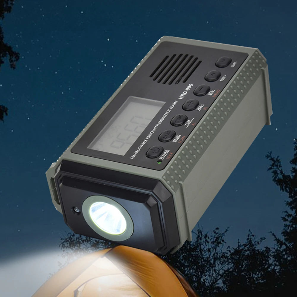 The APWIKOGER 10,000mAh Solar Hand Crank Emergency Radio is a rectangular, handheld device featuring a flashlight, digital display, buttons, and speakers. This multi-band radio is shown against a night sky backdrop with tree silhouettes.