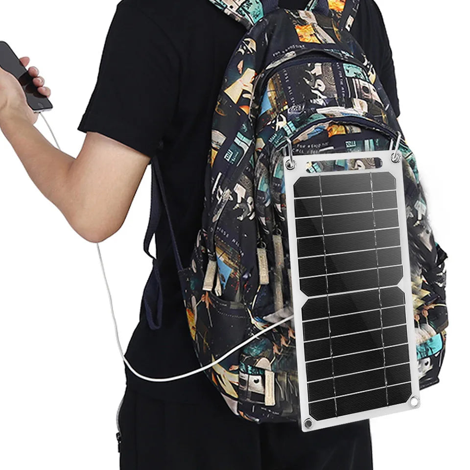 With the EESBAO 35W Solar Panel - Portable USB Charger on their colorful backpack, a person strolls with a phone in hand, perfectly demonstrating solar technology in action—an ideal companion for outdoor camping adventures.
