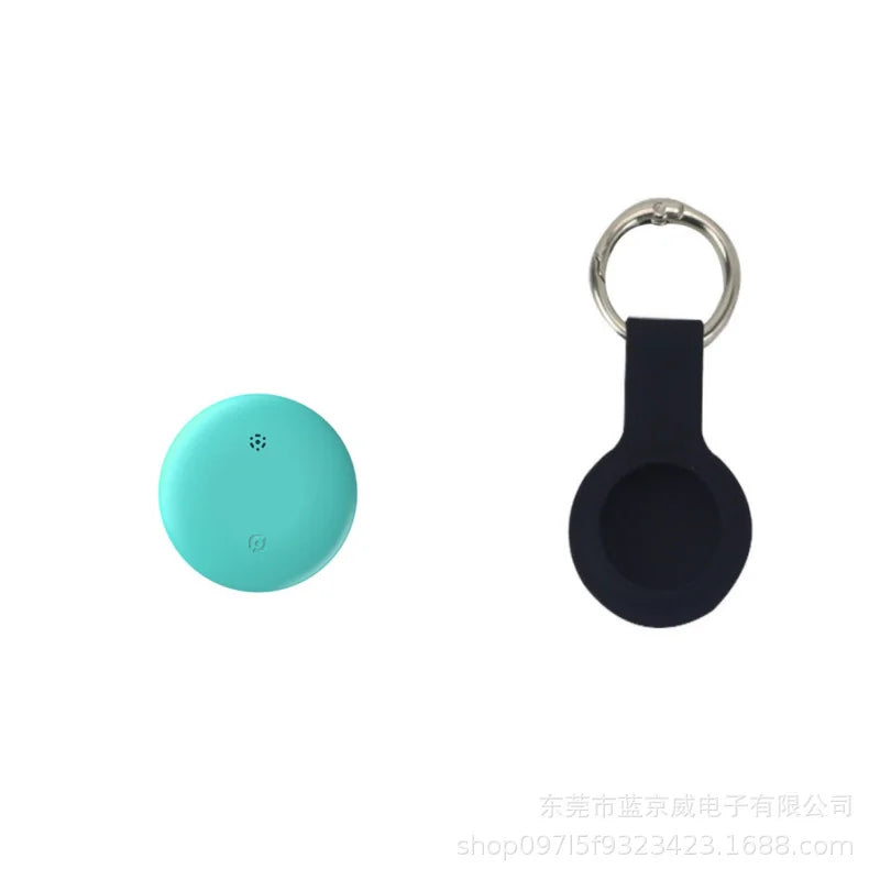 The NoEnName GPS Tracker, a small round turquoise device, sits beside a black keychain holder with a circular slot. Designed for easy attachment and portability, it pairs seamlessly with the Find My App Locator to ensure you never misplace your essentials again.