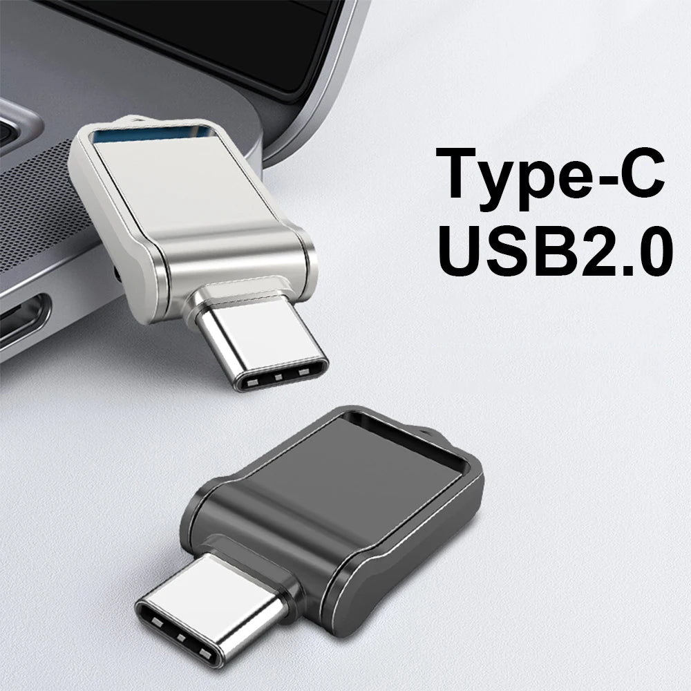 A silver and black USB Type-C adapter, next to a laptop with a sleek MicroDrive Mini USB 2.0 Flash Drive, showcases compact designs and metallic finishes ideal for seamless data transfer.