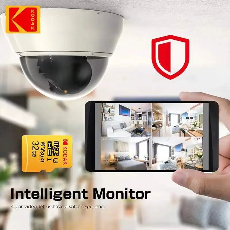 A Kodak security camera, a KODAK 128GB Micro SD Card - Class 10, High-Speed Storage, and a smartphone showing multiple surveillance feeds. Text reads Intelligent Monitor, highlighting clear video for safer experiences.