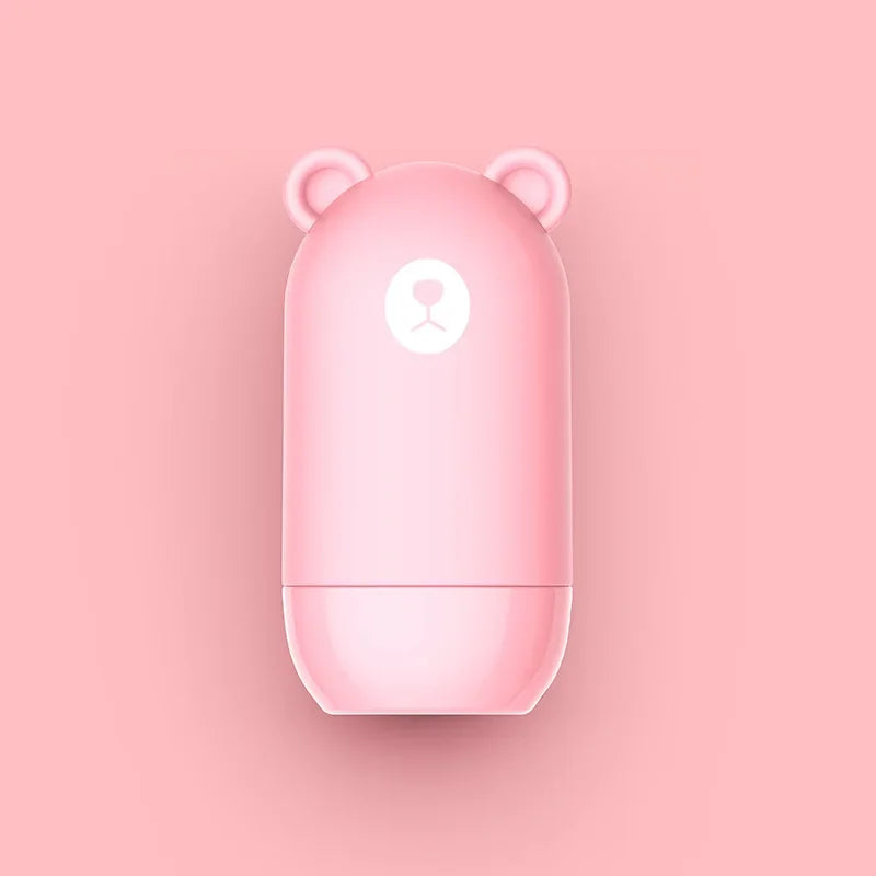 The NoEnName Roller Stamp - Quick Drying Privacy Seal is a pink, capsule-shaped container with bear-like ears and a simple bear face, shown on a matching pink background.