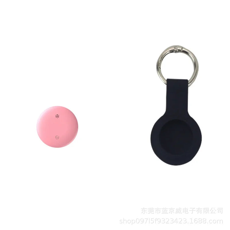 On the left is a small, round pink GPS Smart Tracker called NoEnName GPS Tracker - Bluetooth Locator for Pets. To the right is a black keychain holder with a circular opening that seems to fit the tracker perfectly.
