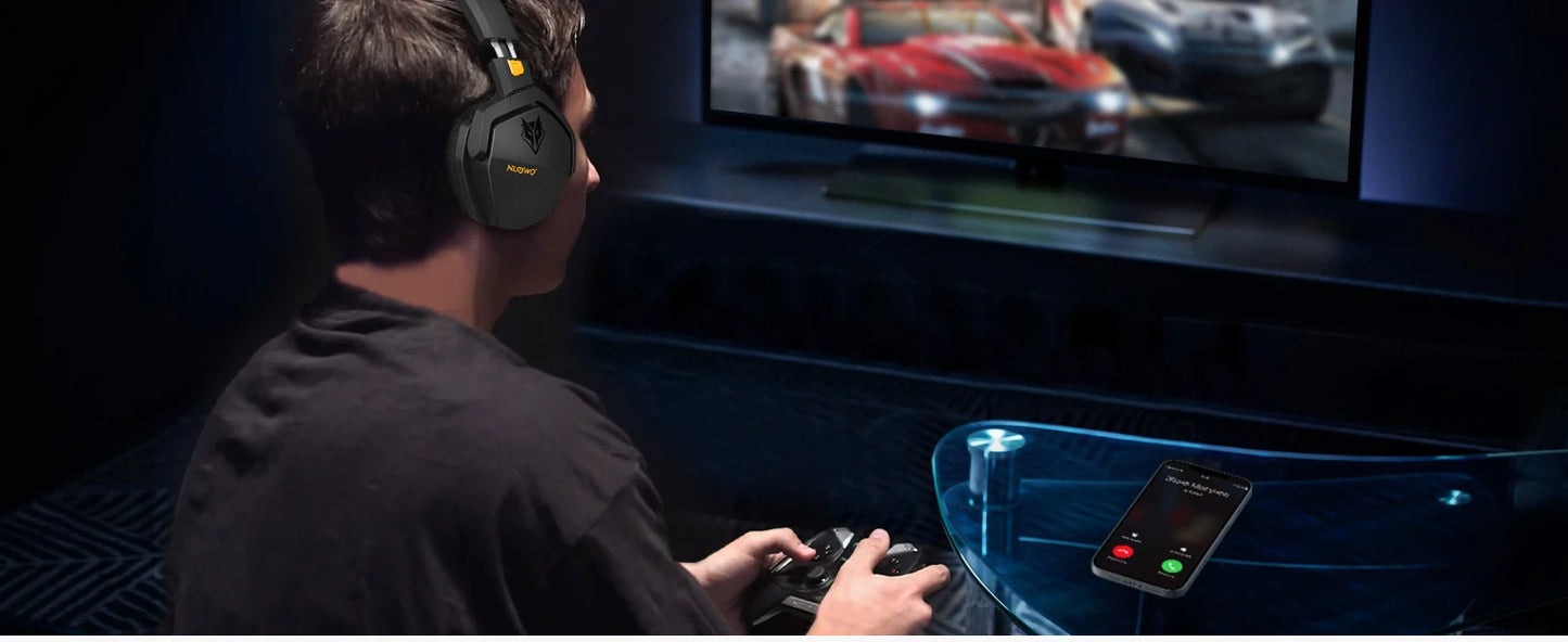 A person is engrossed in a racing game on a big screen, wearing NUBWO G06 Dual Wireless Headset with Active Noise Cancelling, gripping the controller. A phone on the table shows an incoming call with options to accept or decline.
