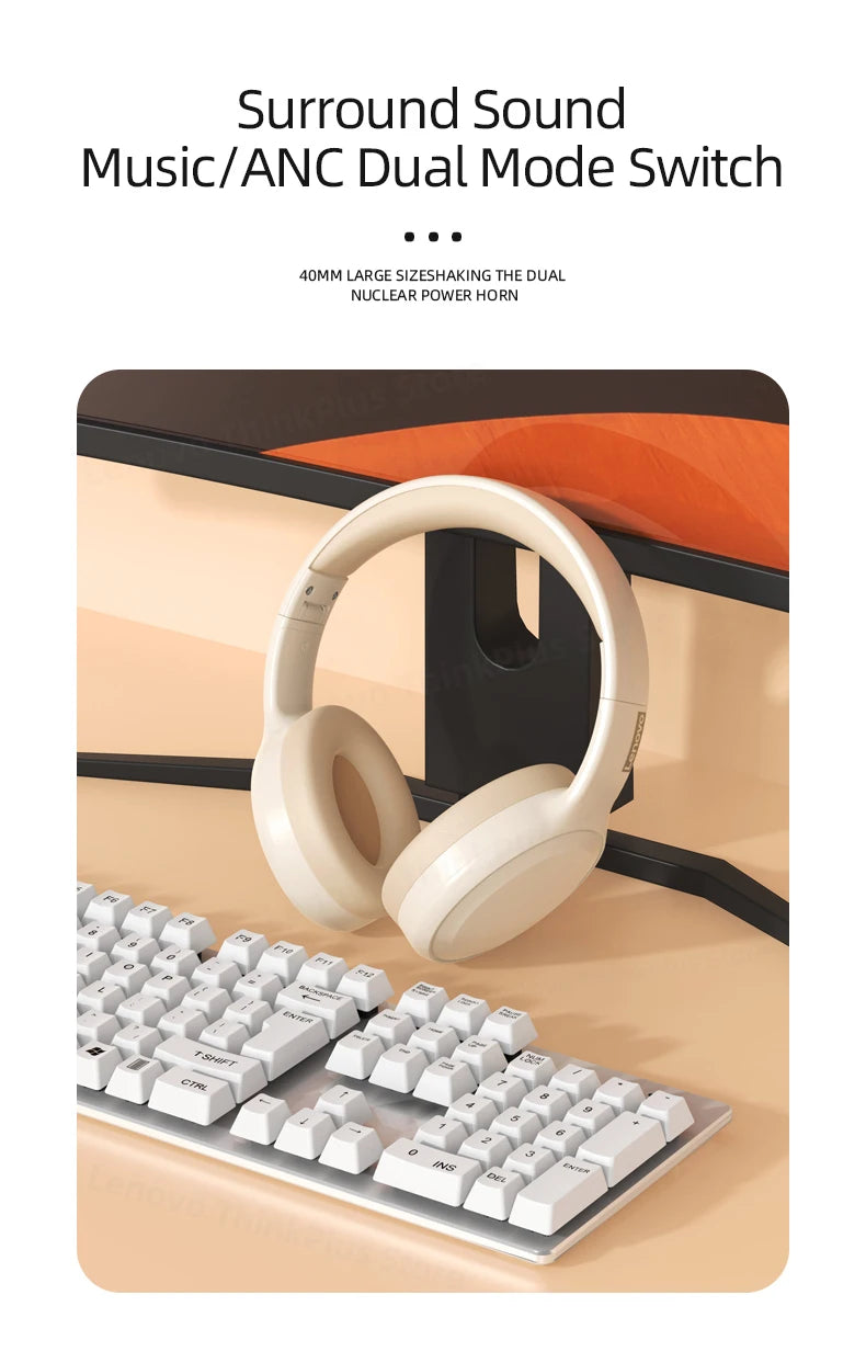A pair of Lenovo TH30 Wireless Headphones (Bluetooth 5.3, Noise Cancelling) hangs on a black stand attached to a computer monitor, with a white keyboard below. Text above reads Surround Sound Music/ANC Dual Mode Switch, ensuring high-fidelity sound and impeccable noise canceling for an immersive experience.