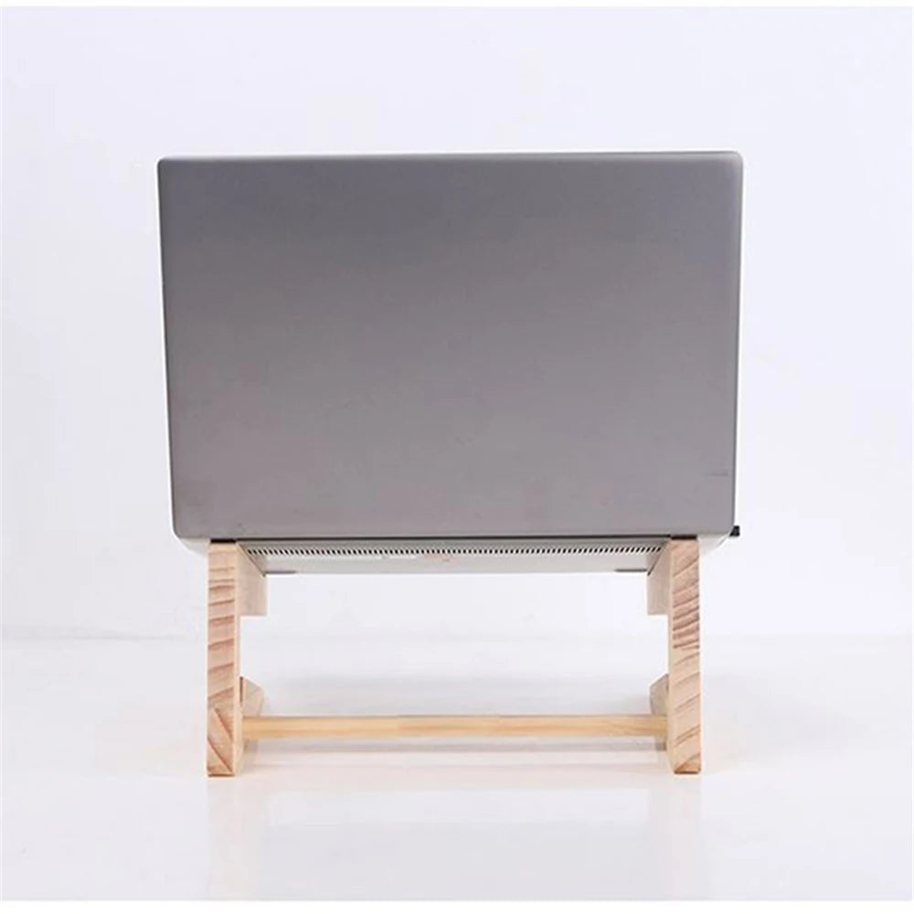 A closed laptop sits on a Universal Wooden Laptop Holder - Detachable Stand, viewed from behind. With a minimalist design featuring two vertical supports and a horizontal base, it elevates the laptop off a white surface. Enjoy free shipping on this stylish accessory.