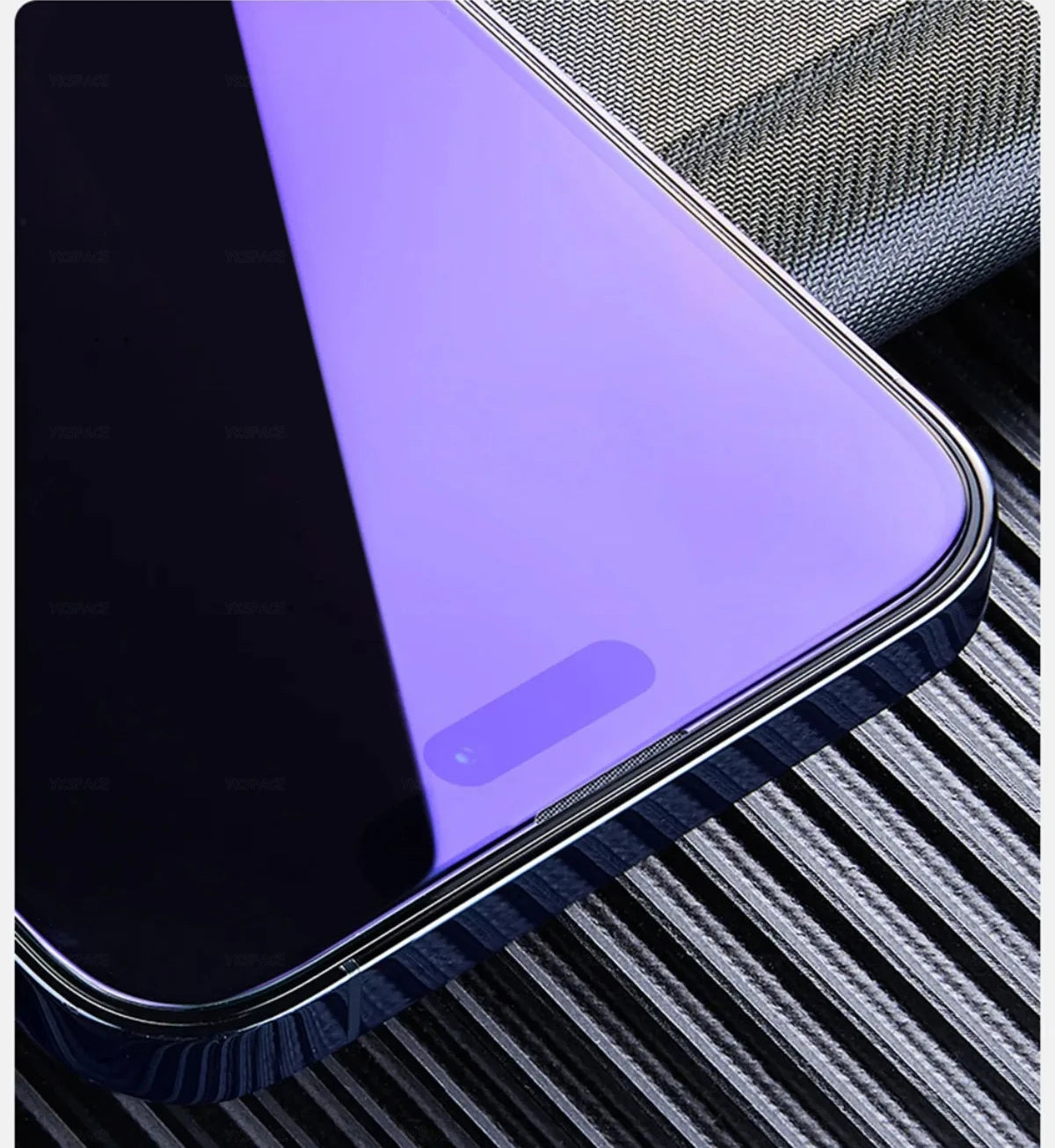 Close-up of a smartphone with YKSPACE 2Pcs Anti Blue-Ray Tempered Glass Screen Protector featuring Eye Care Technology and a front camera cutout, shown on a textured metallic surface.
