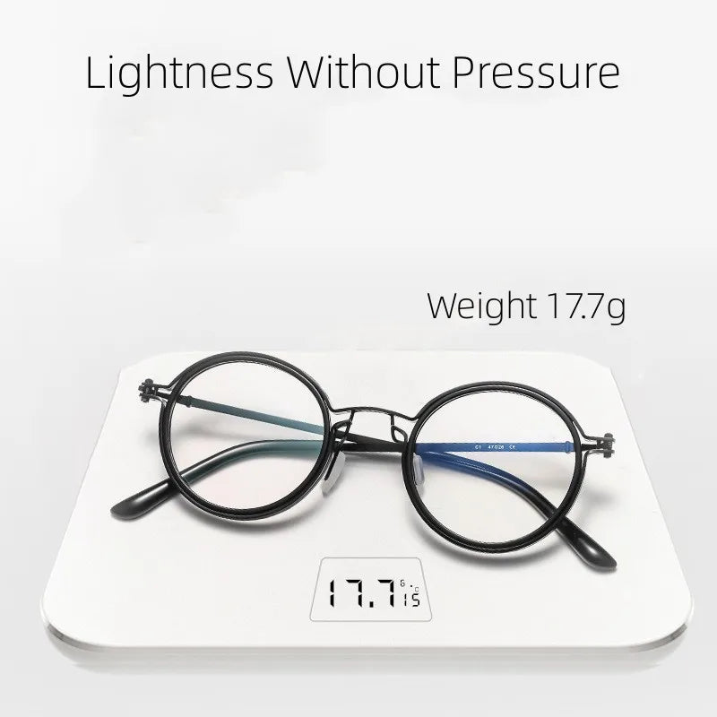 KLASSNUM Mens Round Glasses lie on a digital scale displaying 17.7g. The stylish retro black frames offer Lightness Without Pressure and provide anti-blue light protection without the weight.