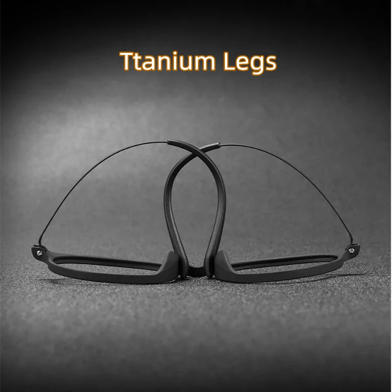 The OUTMIX Pure Titanium Anti Blue Light Reading Glasses, with a sleek titanium frame and thin black rimless design, are displayed on a textured dark surface. Positioned upright with crossed legs, Titanium Legs is elegantly highlighted above in yellow letters.