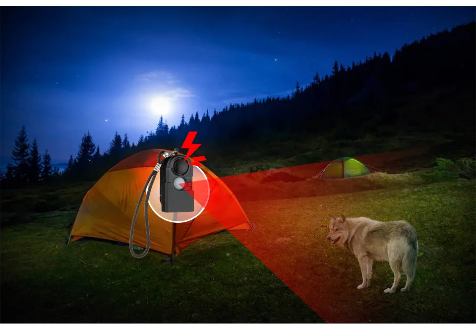 A wolf nears a yellow tent at night in the woods. The KERUI Mini Motion Detector Alarm on the tent emits a 120DB siren and red light, scaring it off. Another tent is seen in the background beneath a starry sky.