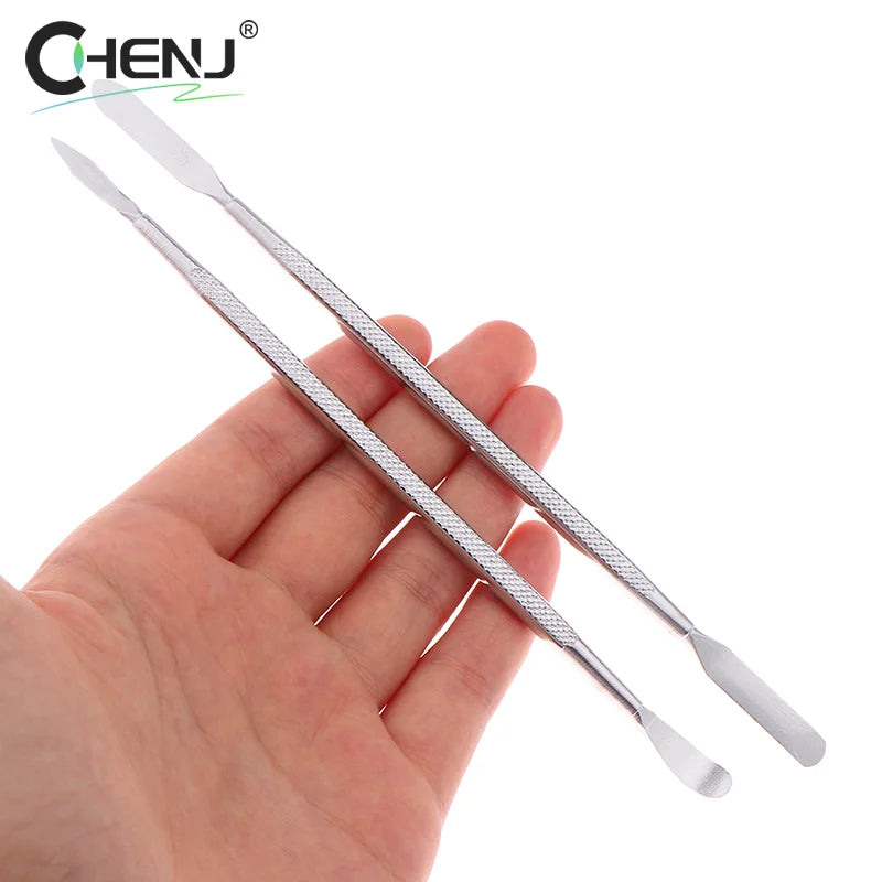 A hand holds two double-ended stainless steel nail cuticle pushers from the 7pcs Metal Spudger Kit, featuring textured grips and positioned horizontally for precision. The CHENJ logo is at the top left corner.
