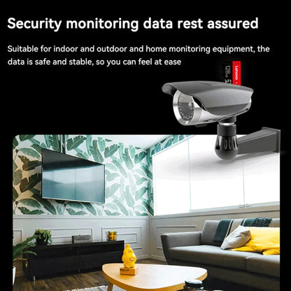 A home interior with a wall-mounted security camera in the living room records every moment securely with a Lenovo 128GB Micro TF Card - Fast 100MB/s Speed. The space boasts a sofa, colorful pillows, and a wooden coffee table with tea essentials against leaf-patterned wallpaper.