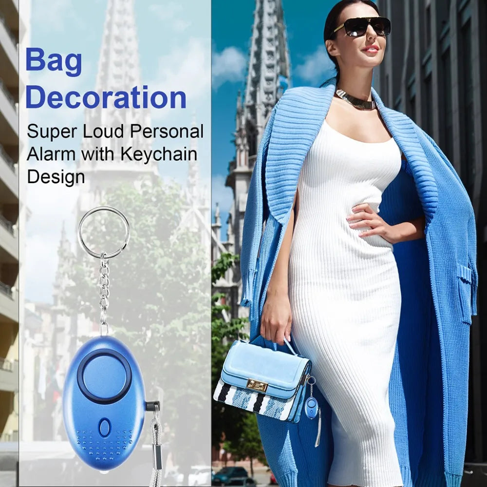 A woman in a white dress and blue coat confidently clutches a blue handbag. Beside her is an image of the 130dB Personal Safety Alarm Keychain for Instant Alerts, highlighting its self-defense essential feature with a stylish design.