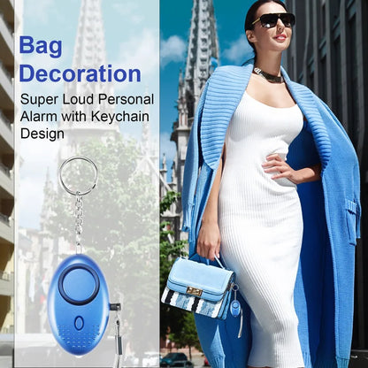 A woman in a white dress and blue coat confidently clutches a blue handbag. Beside her is an image of the 130dB Personal Safety Alarm Keychain for Instant Alerts, highlighting its self-defense essential feature with a stylish design.