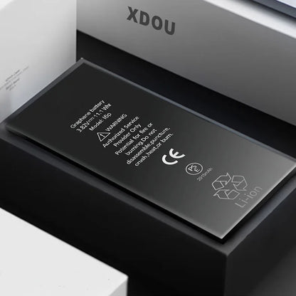 The XDOU Battery for iPhone SE 5-11 Pro offers 3800 mAh and 15 Wh for extended battery life. It features safety warnings, recycling symbols, and a CE mark. The rectangular graphene battery is designed for zero-cycle use and rests on a dark surface with light-edged surroundings.