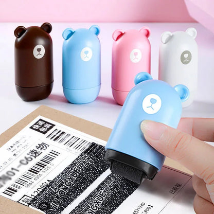Four NoEnName Roller Stamp - Quick Drying Privacy Seal rollers in brown, blue, pink, and white stand on a table. A hand uses the quick drying blue roller to cover text for privacy. Enjoy free shipping!.