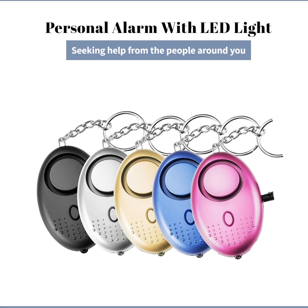Five 130dB Personal Safety Alarm Keychains with LED lights in black, silver, gold, blue, and pink are lined up. Each has a keychain attachment. The text highlights self-defense for seeking help from others.
