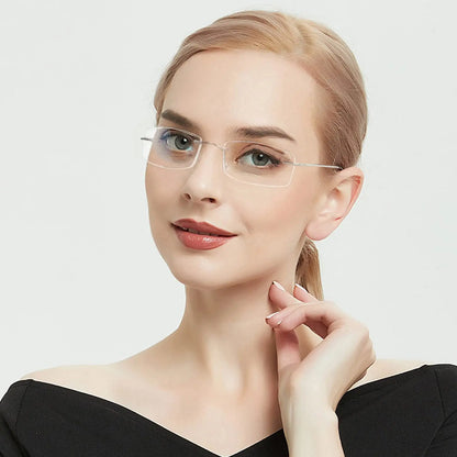 A person with light hair poses confidently against a white backdrop, wearing YINSQER Titanium Rimless Reading Glasses - Blue Light Blocking. They sport a black off-shoulder top, a subtle smile, and gently touch their collar with one hand.