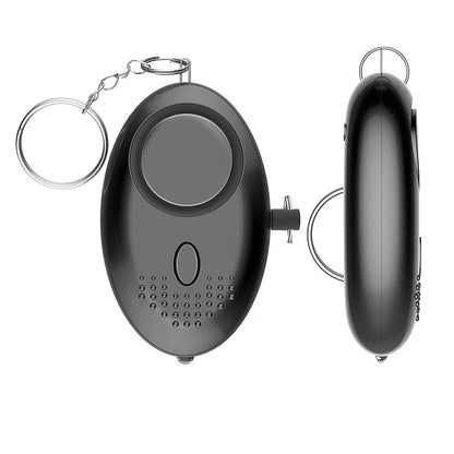 The 130dB Personal Safety Alarm Keychain features a sleek, black oval design with a keyring, large front button, side pin, and perforated sound output. Shown from both front and side views.