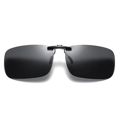 On a white background is a pair of Honey Joe Polarized Clip-On Sunglasses, showcasing sleek, rimless design with dark rectangular lenses and a thin black bridge. The minimalist style enhances modernity and provides UV400 protection.