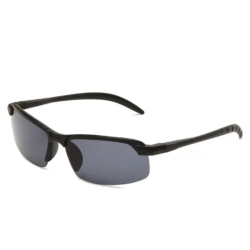 The HARKO Polarized Night Vision Cycling Sunglasses feature a sleek, black, semi-rimless design. Dark-tinted lenses offer a modern look for outdoor adventures, while smoothly curved arms ensure comfort—all set against a plain white background.