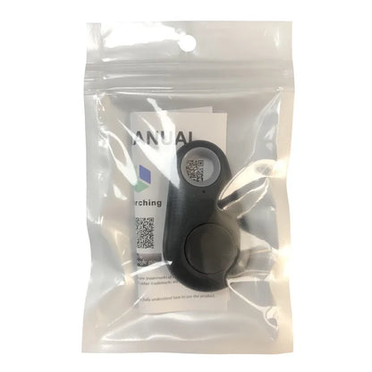 A Seamopar Mini GPS Tracker, compact and black with a loop and button, is in a clear resealable plastic bag. A partially visible manual with text and QR codes is behind it. The packaging highlights the keychains seamless anti-theft alerts and tracking functionality.