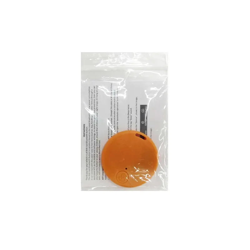 A round orange object sits on a clear plastic bag holding white paper with text and a glimpse of a black item. The sealed bag discreetly contains the Seamopar Mini GPS Tracker, a compact Anti-Lost Bluetooth Key Finder.