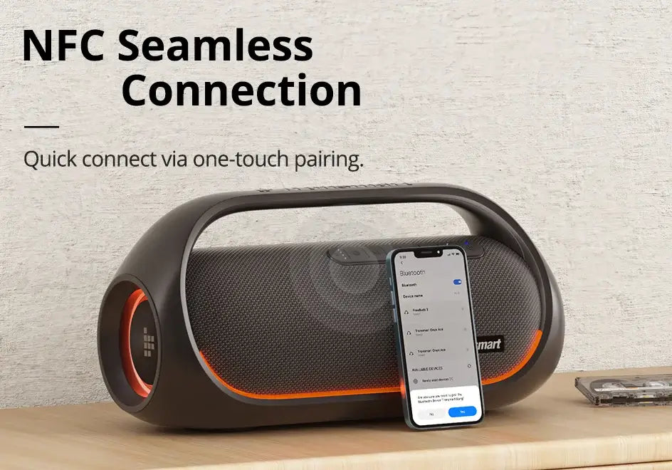 A Tronsmart Bang Speaker 60W rests on a wooden surface, paired with a smartphone showing a Bluetooth connection. Text reads: NFC Seamless Connection—quickly connect via one-touch pairing and enjoy heavy bass at your fingertips with app control.