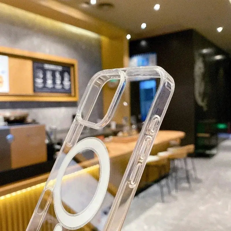 Transparent PC phone case with MagSafe for wireless charging displayed in a modern cafe setting, combining style and functionality.